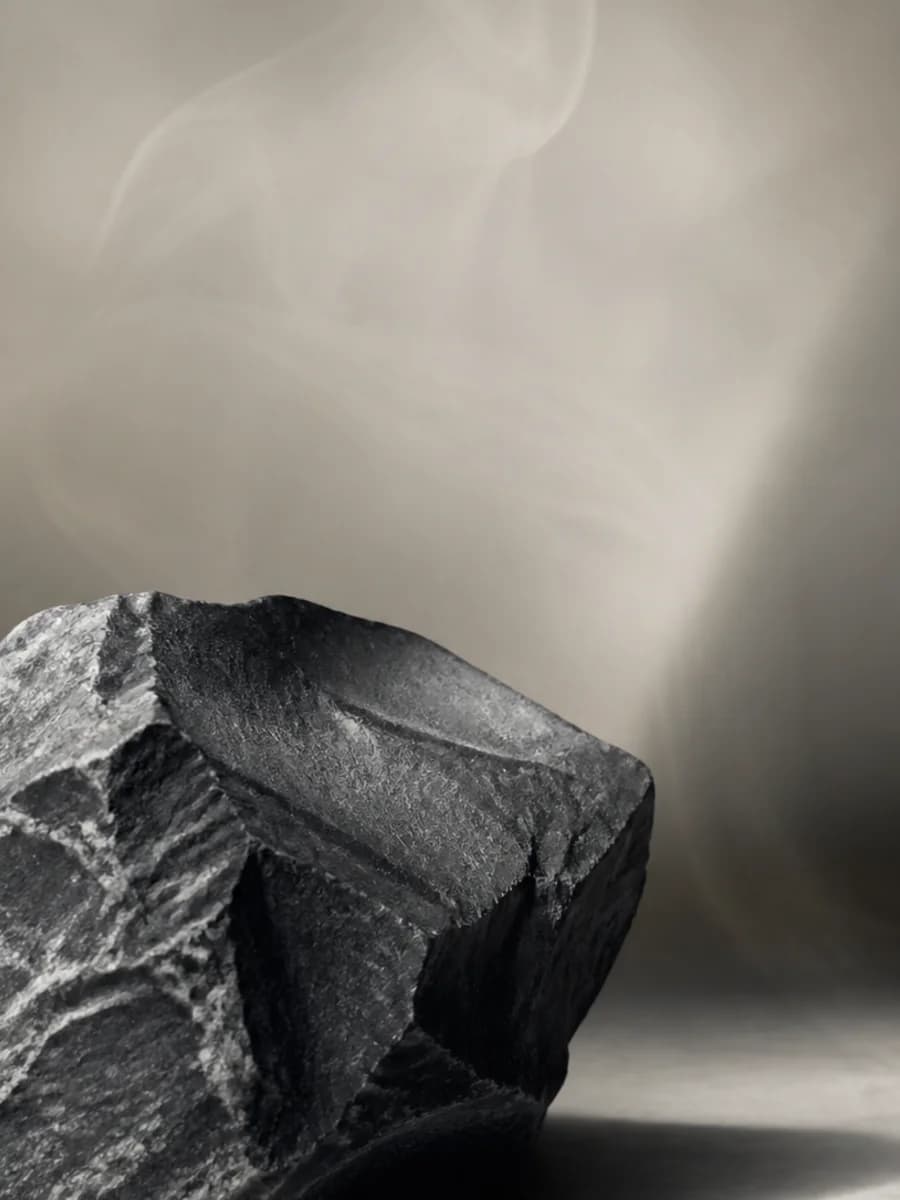 Dunkler Stein mit transparenter, holziger Aura als Material-Editorial